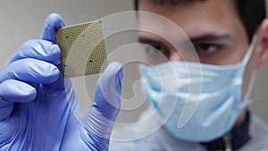 Young Engineer Holds in Hand CPU Processor