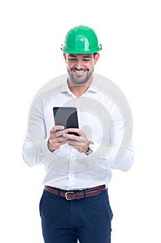 Young engineer man in green helmet using tablet isolated