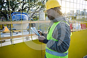 young engineer man at sunset at the construction site reading the tasks done during the working day