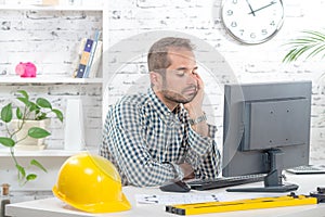 A young engineer pensive at his computer