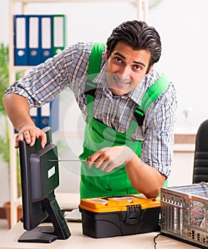Young engineer repairing broken computer at the office