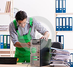 Young engineer repairing broken computer at the office