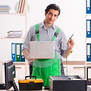 Young engineer repairing broken computer at the office