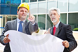 Young engineer showing something to his partner at building site