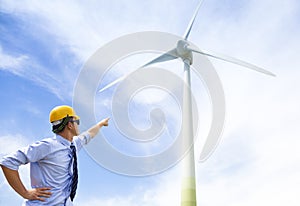 Young engineer standing and point to wind generator