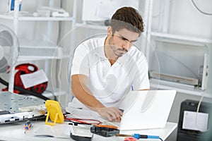 Young engineer taking notes while developping new induction hobs photo