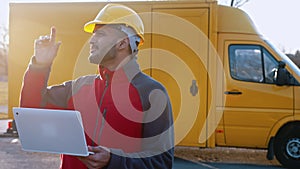 Young Engineer Wearing safety Helmet Holding Laptop Checking His Planned Work