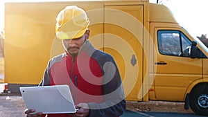 Young Engineer Wearing Safety Yellow Helmet Holding A Laptop In His Hands