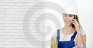 Young engineer woman with safety hard hat talking on phone