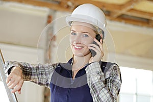 young engineer woman with safety hard hat talking on phone