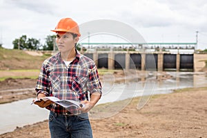 Young engineer working on site at the dam