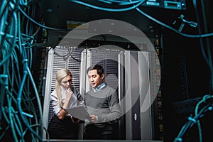 Young engineers businessmen in server room
