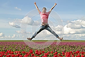 Young enthousiastic guy jumping up