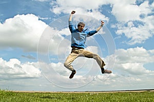 Young enthousiastic guy jumping up