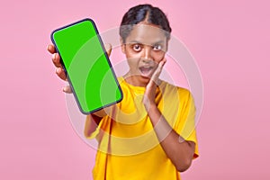 Young enthusiastic Indian woman teenager demonstrates phone and screams WOW