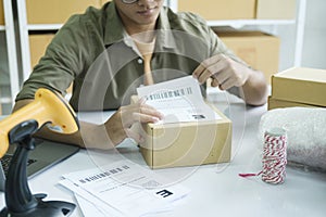 Young entrepreneur packing online order product for shipping.