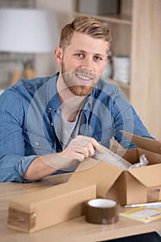young entrepreneur preparing package for shipment