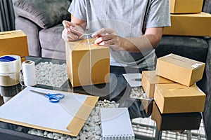 Young entrepreneur SME man receive order client and working with packaging sort box delivery online market on purchase order and