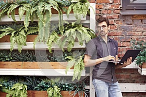 Young entrepreneur working outside using modern laptop. StandingYoung entrepreneur working outside using modern laptop. Standing