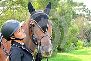 Young equestrian speaking to her horse