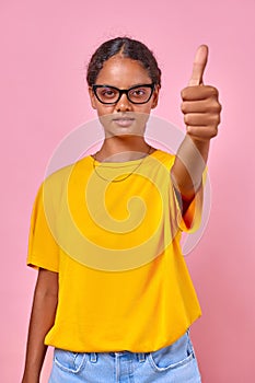 Young ethnic Indian millennial woman showing thumbs up stands in studio