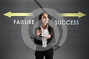 Young european businesswoman with coffee cup and failure and success arrows sketch on concrete background. Direction, growth,