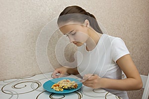 Young European girl with long hair eating eggs