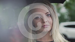 a young European girl stands with a black umbrella