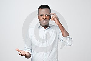 Young european man in white shirt dissatisfied frowns and looks sullenly. photo