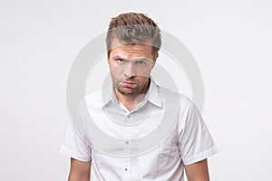 Young man dissatisfied frowns and looks sullenly. Wrinkles on the forehead of negative events photo