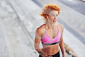 Young european redhead woman in sportive clothes running outdoors