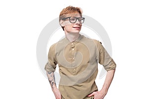 young european slender man with red short hair and a tattoo on his arm on a studio background with copy space