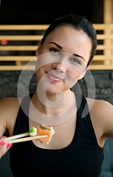 Young European woman eating sushi in an Asian restaurant