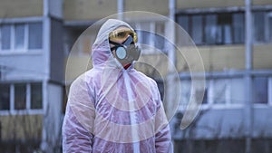 The young europeans man in protective chemical suit and respirator, outdoors. New coronavirus COVID-19