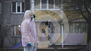 The young europeans man in protective chemical suit and respirator, outdoors. New coronavirus COVID-19