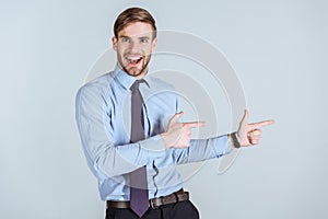 Young excited businessman pointing 