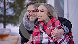 Young excited Caucasian man and woman talking smiling admiring beautiful winter nature outdoors. Portrait of happy