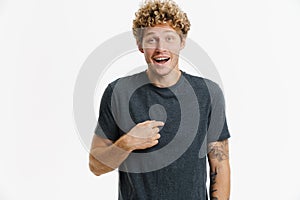 Young excited man laughing while pointing finger at himself