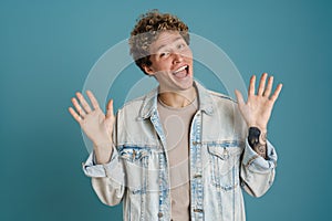 Young excited man wearing jacket gesturing and exclaiming