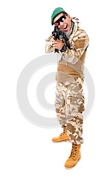 Young excited soldier in army clothes and camouflage aiming with