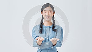 young excited woman standing happy smiling holding her hand showing something on the open palm isolated over white background