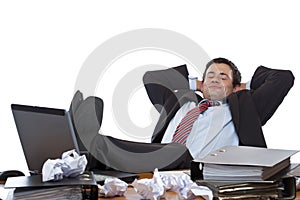 Young executive relaxes with feet at desk