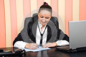 Young executive woman writing on papers