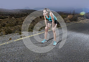 Young exhausted sport woman running outdoors on asphalt road stop for breathing and having a rest after massive effort