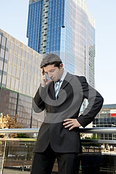 Young exhausted and worried businessman standing outdoors in stress and depression