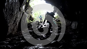 Young explorer standing in a cave with climbing equipment ready for action, travelling and extreme concept. Stock