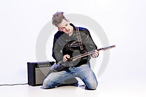 Young expressive rock musician playing electric guitar and singing. Rock star
