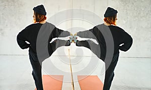 Young extraordinary hipster girl in casual close reflection in the mirror, making yoga pose.