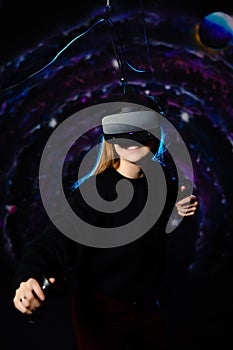 Young fair-skinned girl playing a game using virtual reality glasses