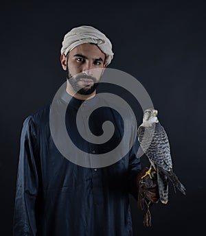 Young falconer holding a bird of prey.